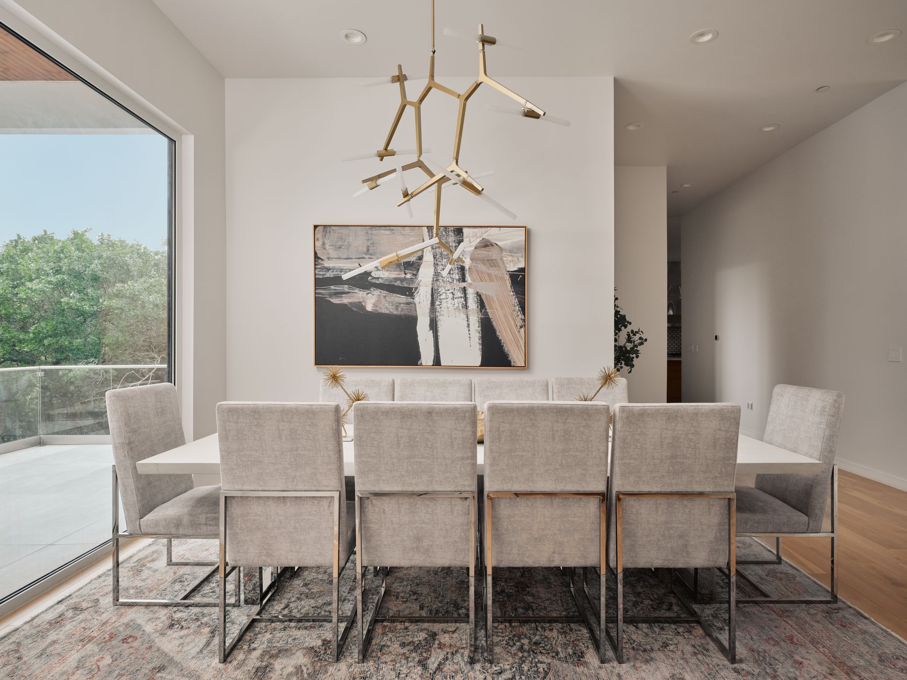 2476 Waymaker Way Austin, TX 78746 - Photo 6 of 31 Elegant dining space featuring a unique chandelier and ample natural illumination from the adjacent patio.