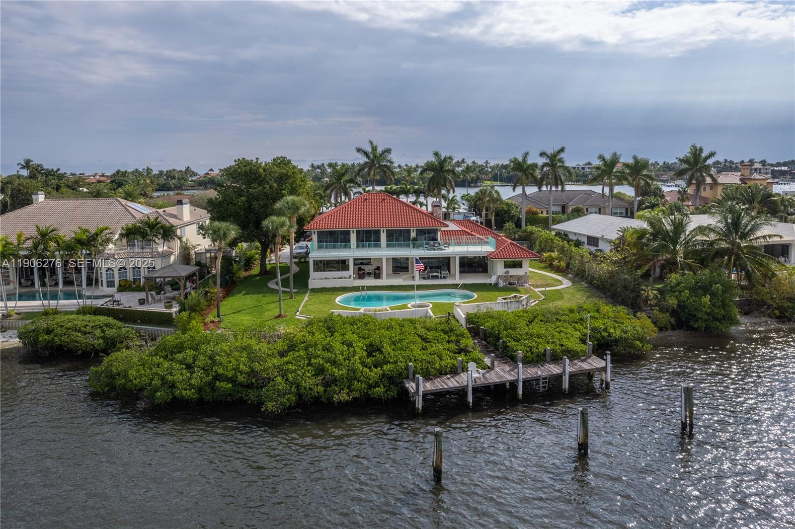 1635 Lands End Road Manalapan, FL 33462 - Photo 14 of 38 a view of a big yard with table and chairs under an umbrella