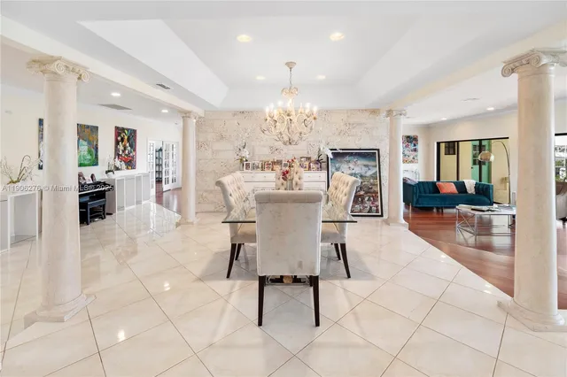a dining room top with furniture a chandelier and kitchen view