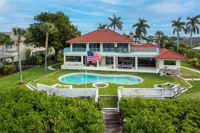 an aerial view of a house with swimming pool patio and outdoor seating