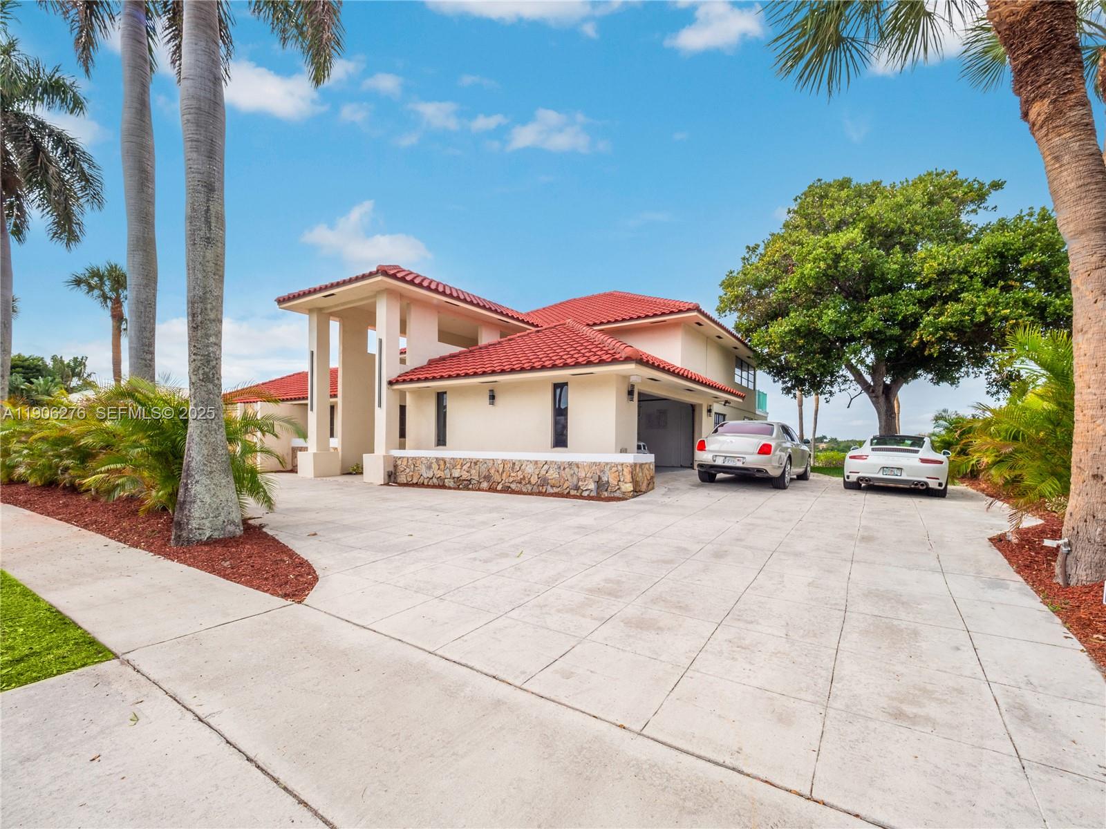 1635 Lands End Road Manalapan, FL 33462 - Photo 29 of 38 a front view of a house with a yard and garage