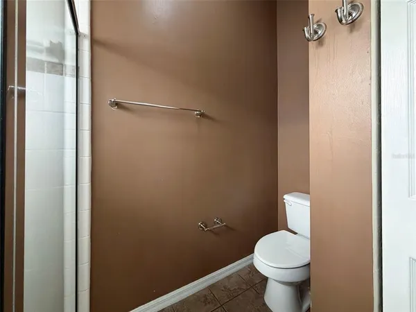 a white toilet sitting next to a shower