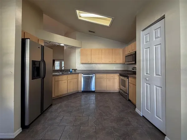 a kitchen with a refrigerator sink and cabinets