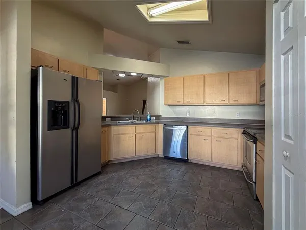 a kitchen with a refrigerator sink and cabinets