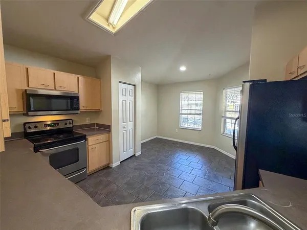 a view of kitchen with sink and refrigerator
