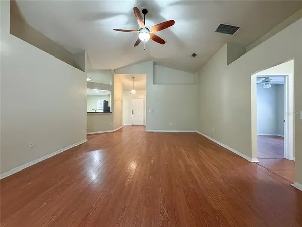 a view of empty room with wooden floor