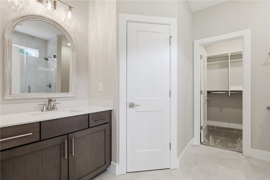736 Stewart Gin Road Liberty, SC 29657 - Photo 28 of 50 This primary bathroom features a stylish vanity, a spacious shower, and a walk-in closet.