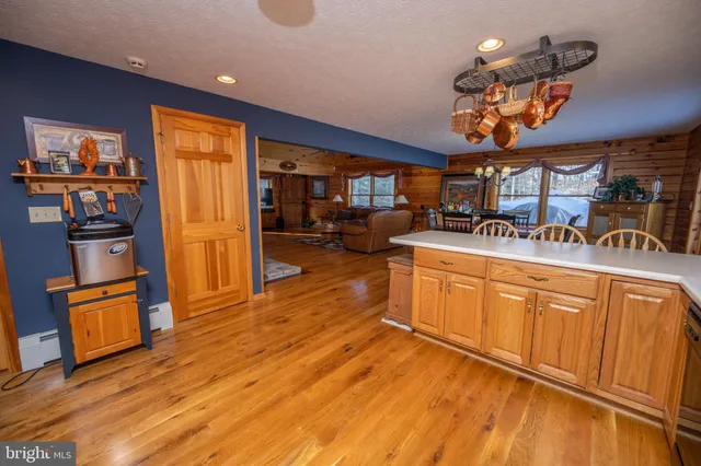 a kitchen with stainless steel appliances granite countertop a refrigerator a sink a stove and oven with wooden floor