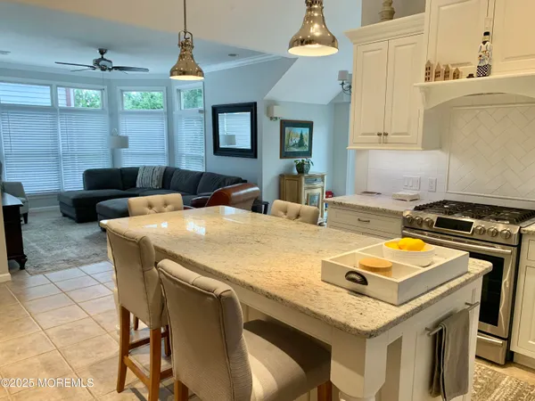 a kitchen with a stove a sink dishwasher a dining table and chairs with wooden floor