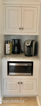 a cabinet with white cabinets and appliances
