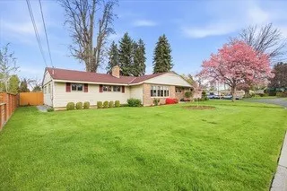 a view of an house with backyard and a tree