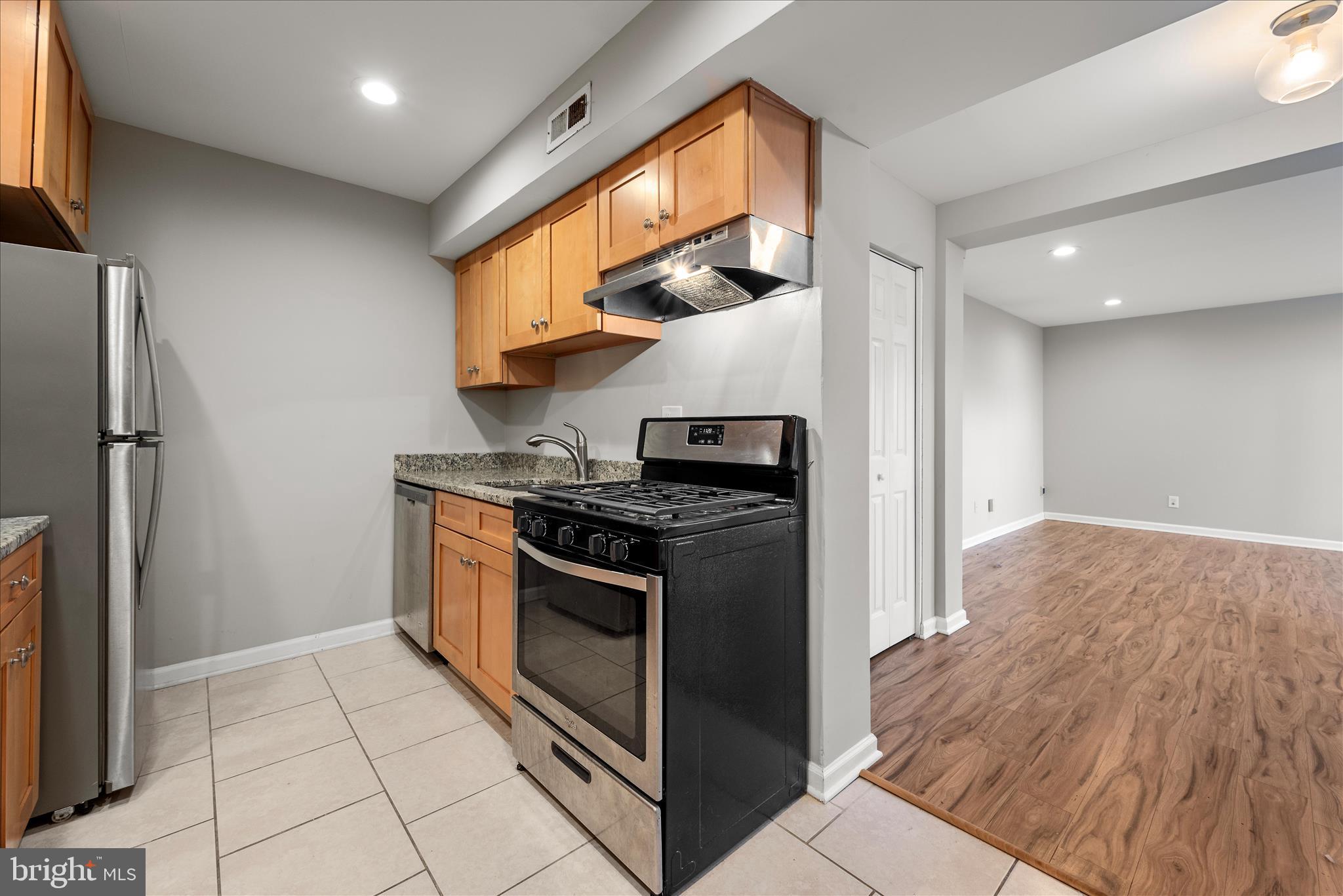 156 Haycock Road, Unit A6 Falls Church, VA 22046 - Photo 23 of 30 a kitchen with stainless steel appliances granite countertop a stove a refrigerator and a cabinets