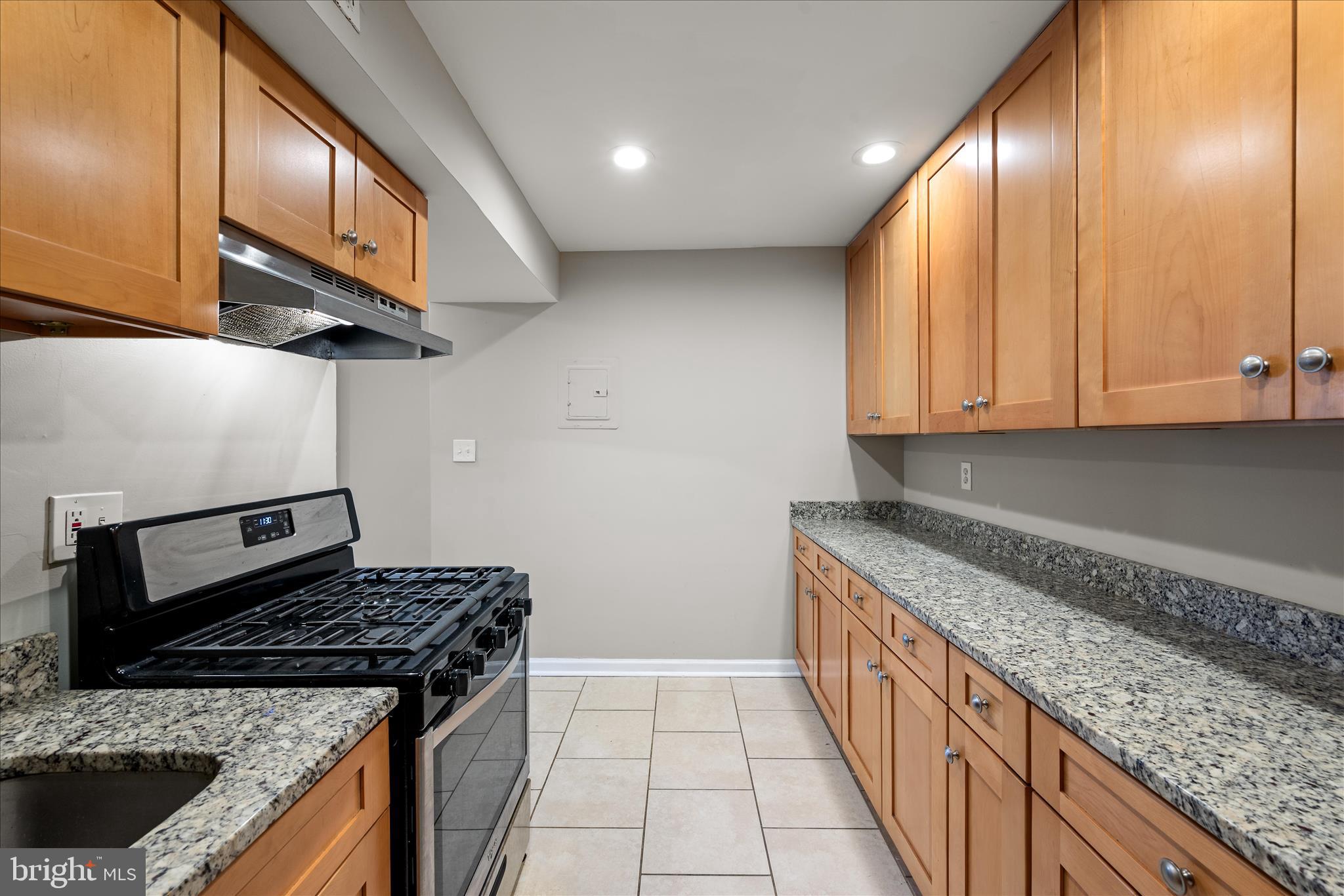 156 Haycock Road, Unit A6 Falls Church, VA 22046 - Photo 25 of 30 a kitchen with granite countertop a stove and a sink