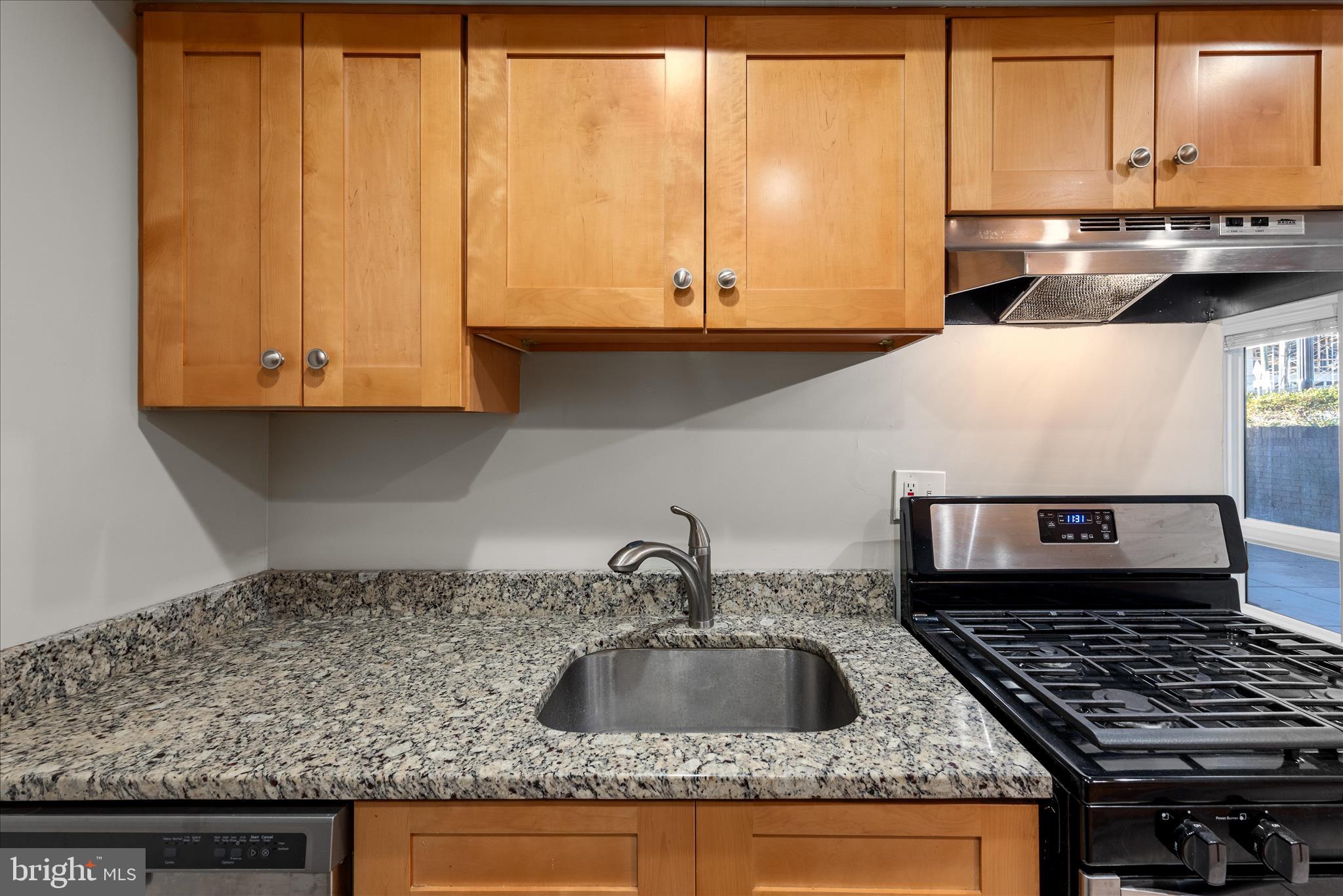 156 Haycock Road, Unit A6 Falls Church, VA 22046 - Photo 26 of 30 a kitchen with granite countertop a sink a stove and cabinets