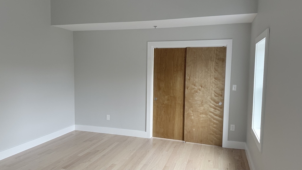 944 East Street, Unit 3 Walpole, MA 02081 - Photo 14 of 23 an empty room with wooden floor door and closet