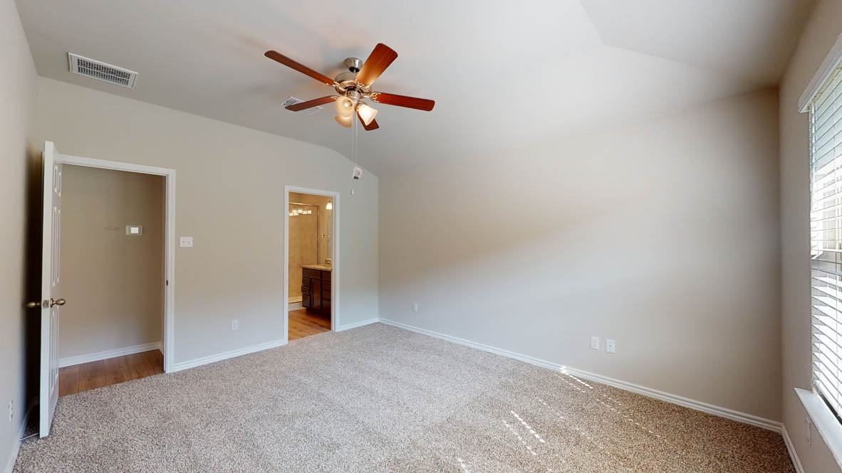 429 Creekfall Road Burnet, TX 78611 - Photo 15 of 28 A comfortable bedroom with a vaulted ceiling and direct access to a private bathroom.