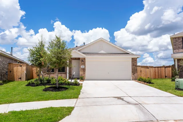 a front view of house with yard and trees all around