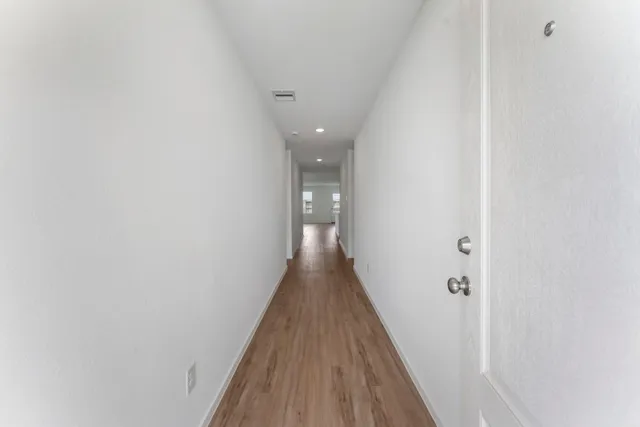 a view of a hallway with wooden floor