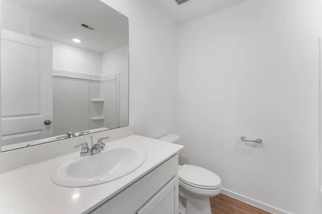 a bathroom with a sink toilet and a mirror