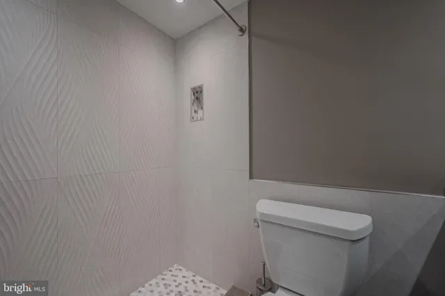 a white toilet sitting next to a shower