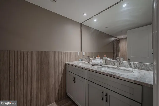 a bathroom with a granite countertop sink and a mirror