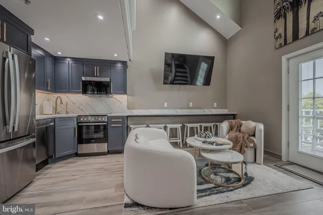a living room with stainless steel appliances kitchen island granite countertop furniture and a kitchen view