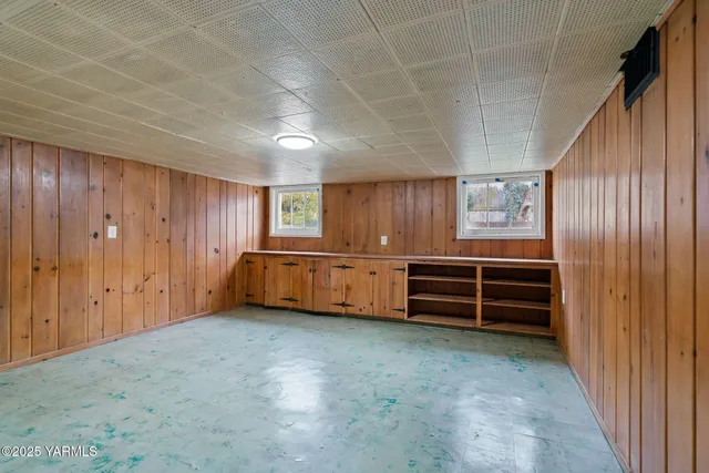 a view of an empty room with a cabinet and mirrors
