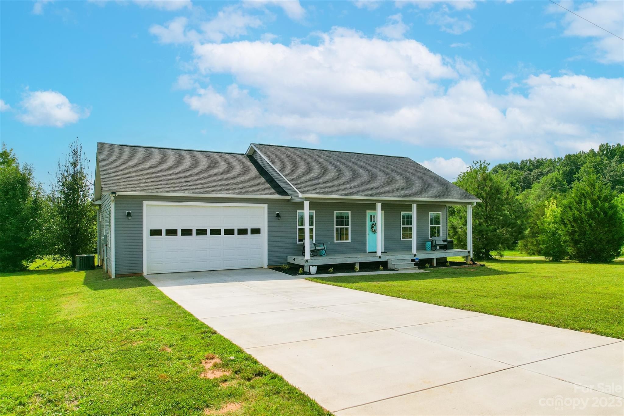 a view of a big house with a big yard and large trees