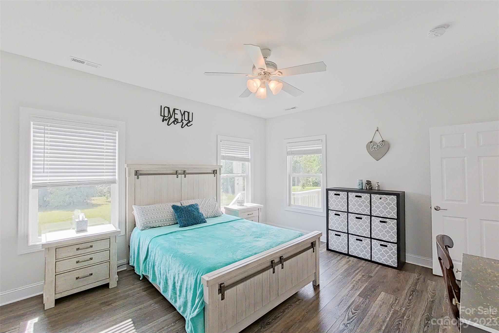 345 Rash Road Olin, NC 28660 - Photo 16 of 39 a bedroom with a bed a dresser and wooden floor