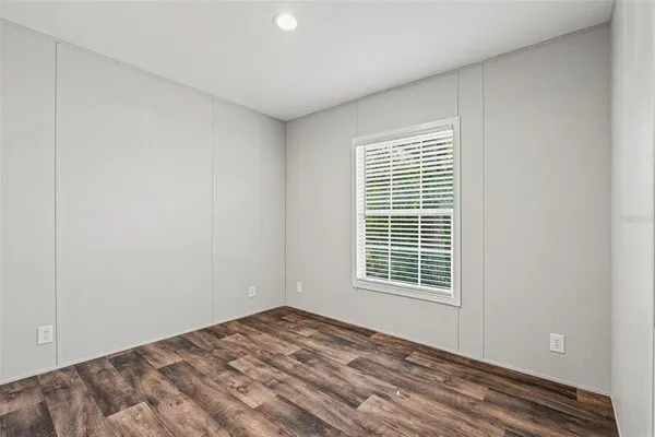 a view of empty room with wooden floor