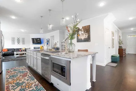 a kitchen with a sink stove and wooden floor