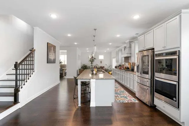 a view of a kitchen with kitchen island stainless steel appliances refrigerator stove microwave and cabinets