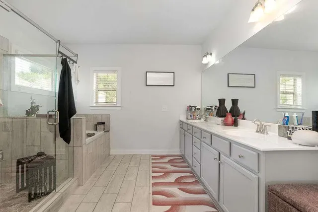 a bathroom with a sink a toilet a mirror and shower