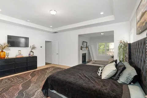 a bedroom with a bed window and a television