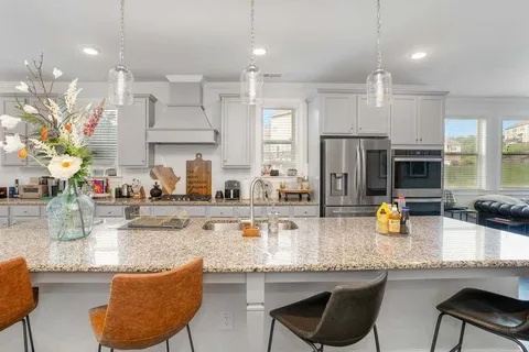 a kitchen with stainless steel appliances granite countertop a sink and a refrigerator