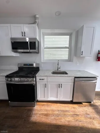a kitchen with stainless steel appliances a stove a sink and a microwave