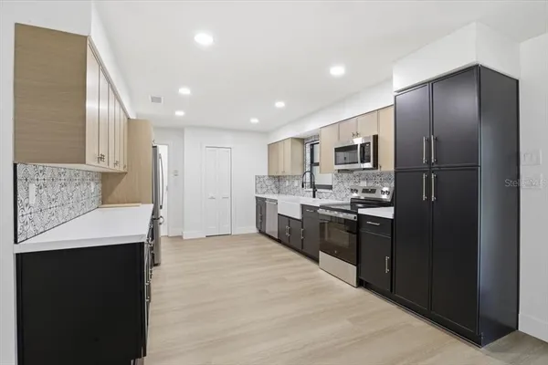 a large kitchen with a refrigerator and a sink