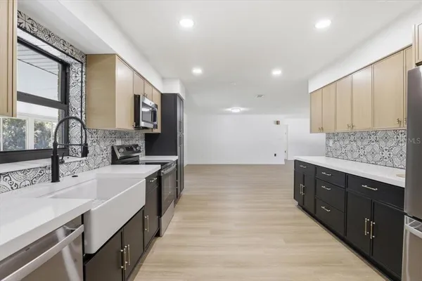 a large kitchen with stainless steel appliances double vanity and a sink