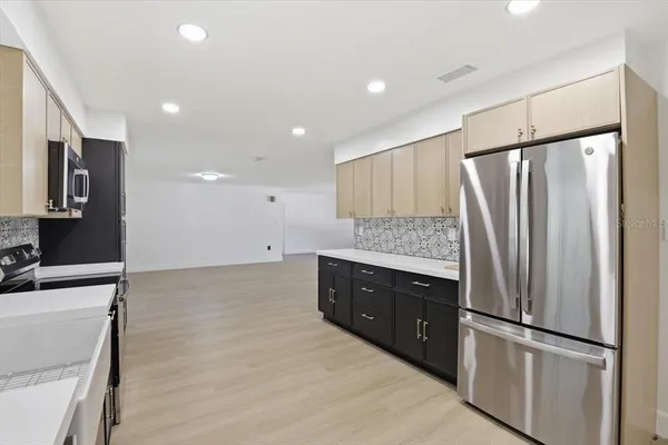 a kitchen with stainless steel appliances granite countertop a refrigerator and a sink