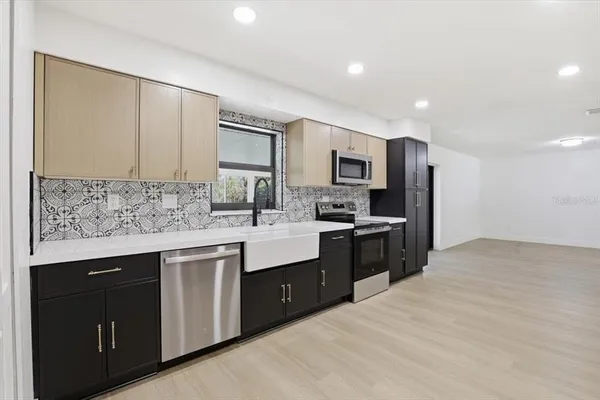 a kitchen with stainless steel appliances a sink stove and refrigerator