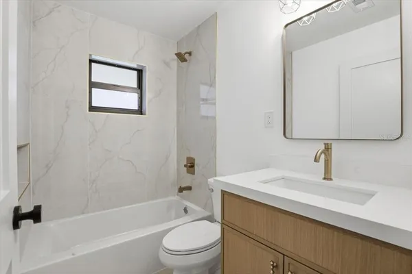 a bathroom with a toilet a sink a mirror and a bathtub