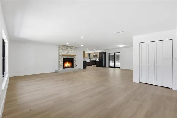 an empty room with fireplace and wooden floor