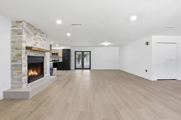 a view of empty room with wooden floor and fireplace