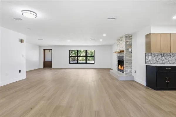 a view of an empty room with a window and fireplace