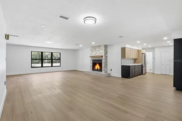 a view of empty room with a kitchen and fireplace