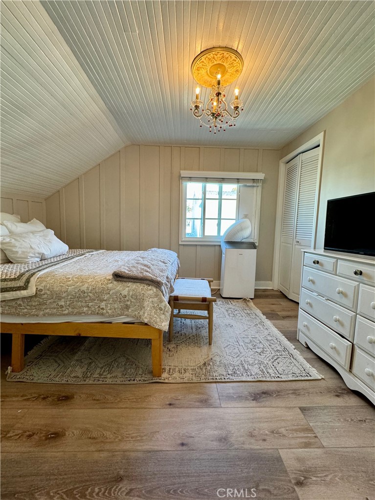 437 Cypress Drive, Unit B Laguna Beach, CA 92651 - Photo 17 of 20 a bedroom with a bed and a chandelier