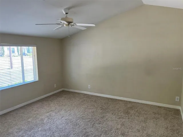 an empty room with a window and a fan