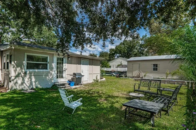 a backyard of a house with table and chairs