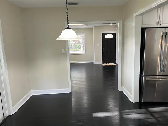 a view of a kitchen with wooden floor and a window