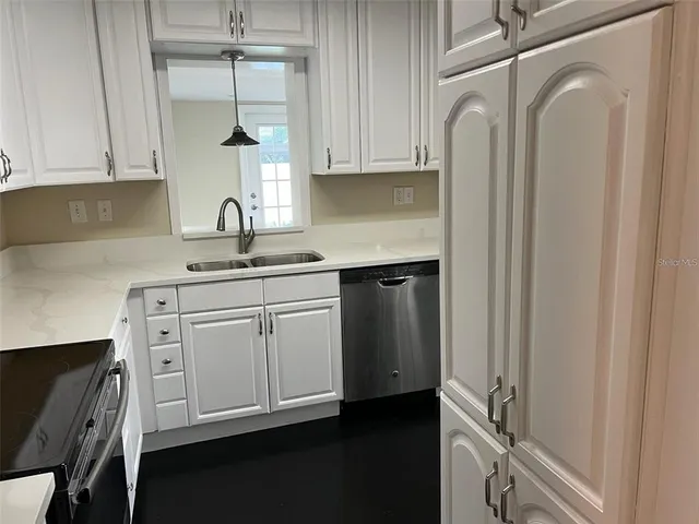 a kitchen with a sink cabinets and a window
